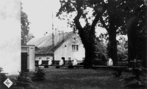 Blick von der Westpforte zum Pfarrhaus hin. das Gelände hier liegt 1,5 m über dem des Pfarrhofes. An der Südwestecke des Kirchenbaus - wenige Meter zurück - ist das gut erhaltene Portal der Kellergruft Lambeck erkennbar. Vorn rechts bei dem Tännchen war einst die Grabstelle Strehlau.